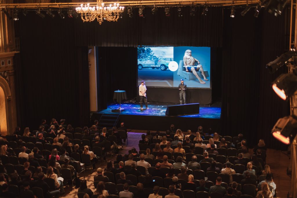 Audience watching George and Tom McQueen at Grand One AI Day 2025